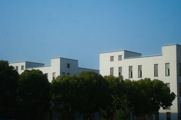a white building with trees in front of it