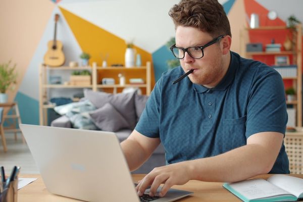 Man working on a laptop at a desk.