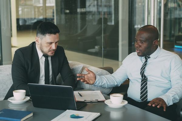 Two businessmen discussing a project at a table.