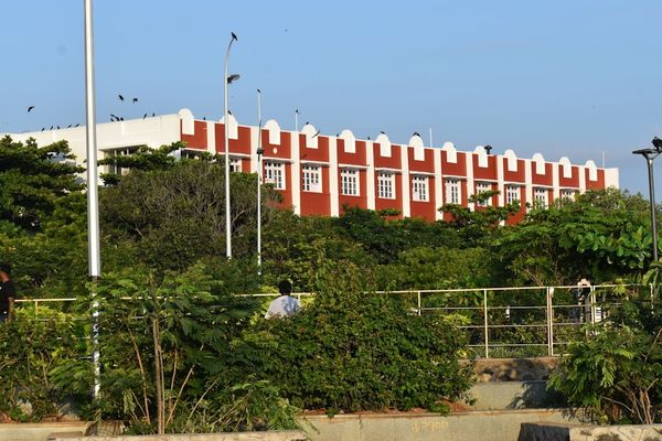 A red and white building sitting next to a lush green park