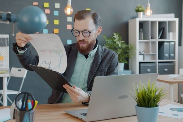 Man in office reviewing documents at desk documents