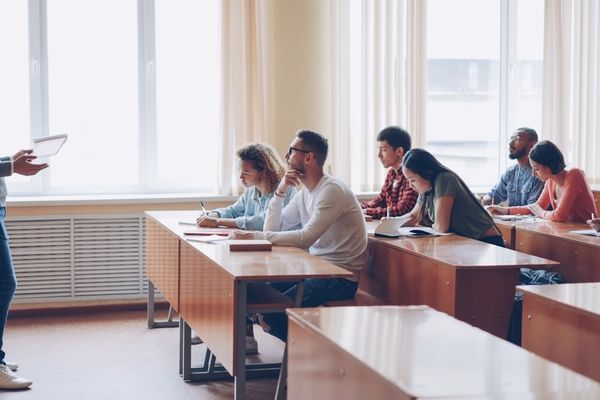 Teacher instructing students in a classroom lecture.
