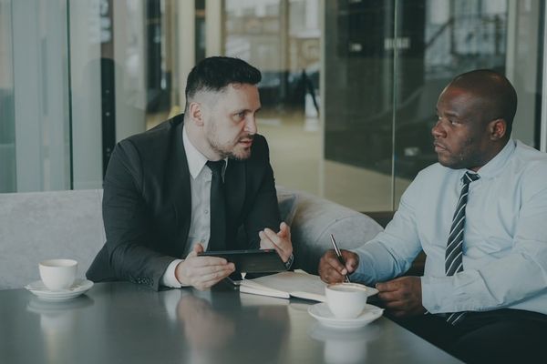 Two businessmen discussing work over coffee.