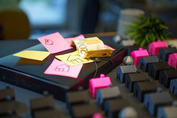 Miniature houses and sticky notes with house drawings.