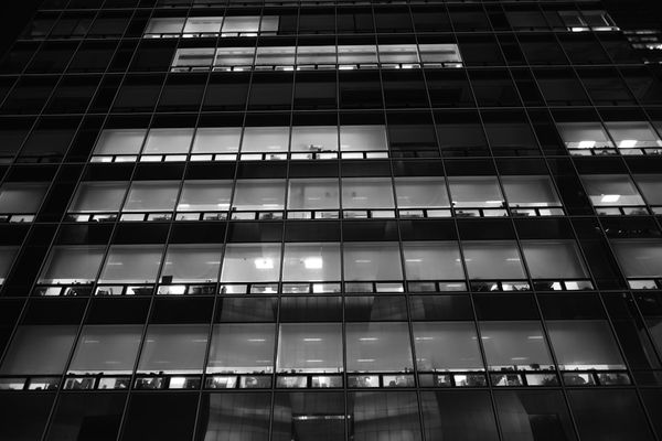 A very tall building with lots of windows at night