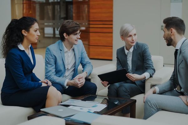 Four business people in a meeting discussing documents.