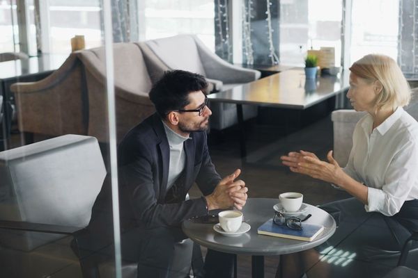 a man and a woman sitting at a table talking