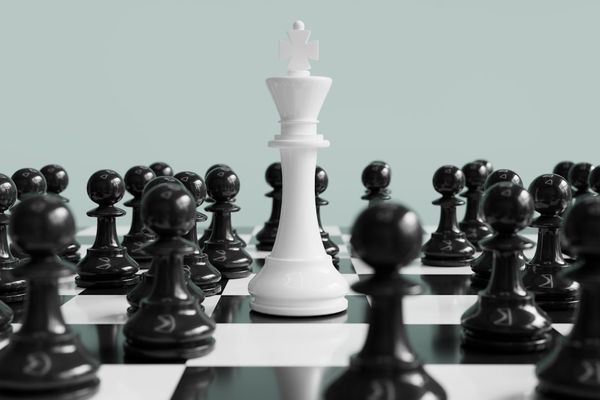 White king stands surrounded by black pawns.