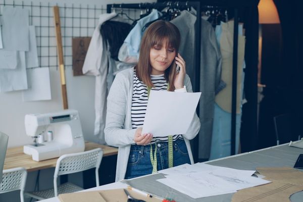 A seamstress talks on the phone in her studio.
