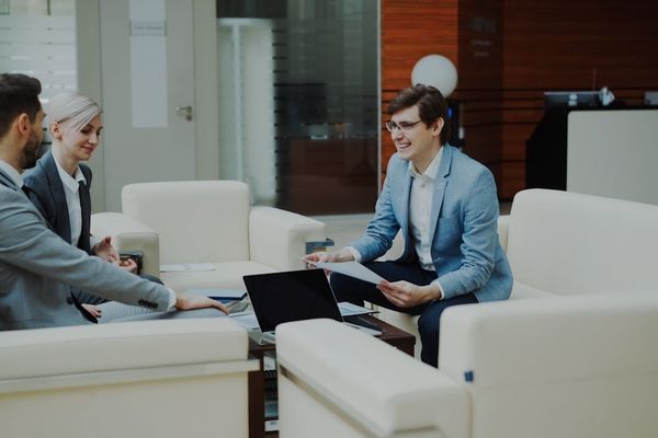 Three business people in a modern office meeting.