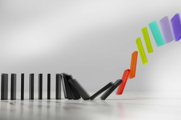 Colorful dominoes falling in a chain reaction