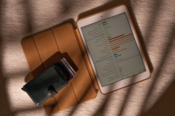 a tablet computer sitting on top of a table next to a wallet