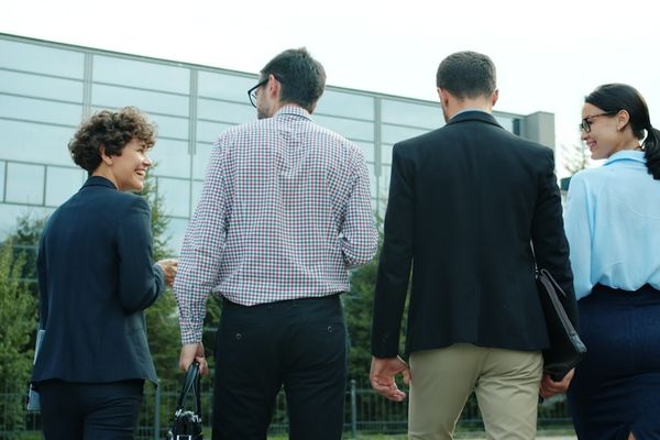 Four business people walking away from camera
