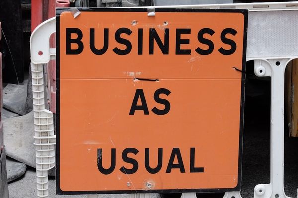 A sign that says business as usual on it