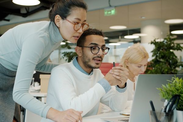 Two colleagues collaborating on a computer screen.