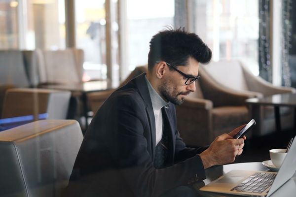 a man sitting at a table using a cell phone