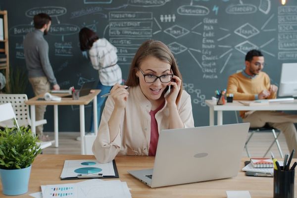 Woman celebrating success while on a business call.