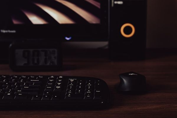 a computer keyboard and mouse on a desk