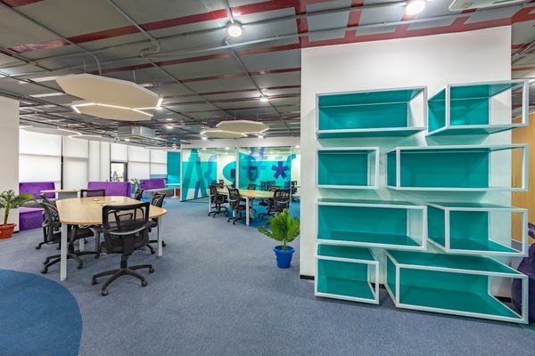 a large open office space with a bookcase and desks