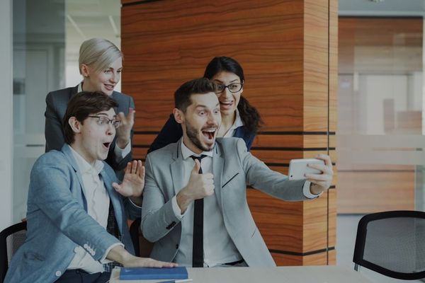Team celebrates success while taking a selfie