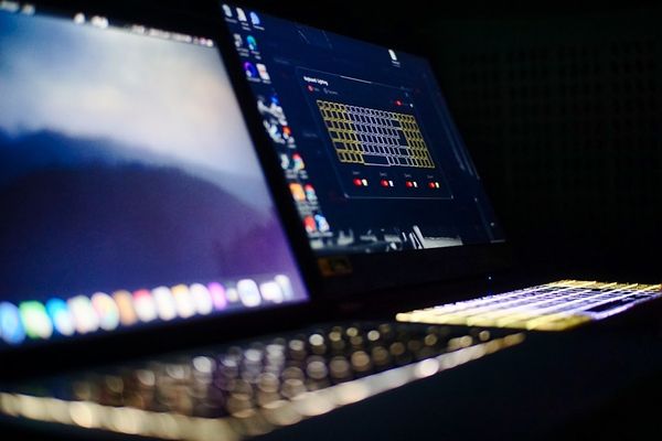 black laptop computer turned on displaying music player