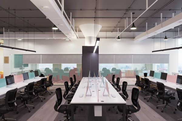 an office with a long white table and black chairs