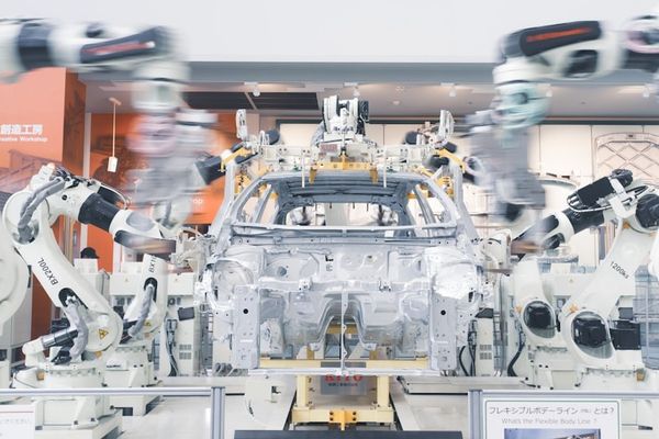 Robotic arms assembling a car chassis on a factory line.