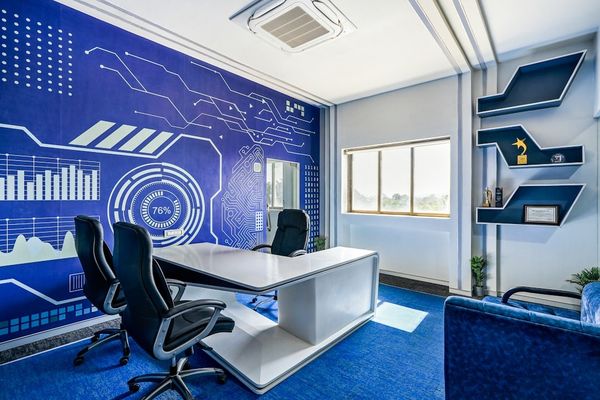 a room with a blue wall and a white desk