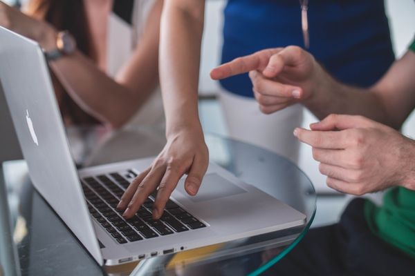 person touching and pointing MacBook Pro
