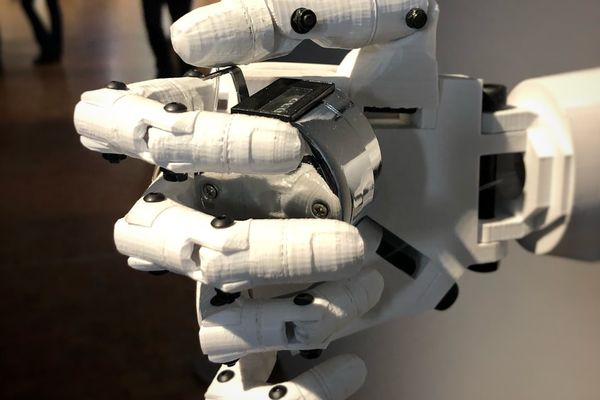 a robotic hand that is holding a laptop