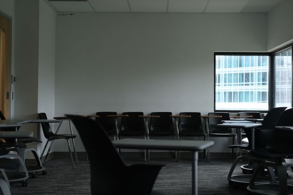 Empty classroom with desks and chairs near window
