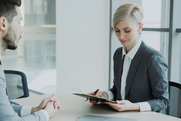 Woman in suit reviews document with man.