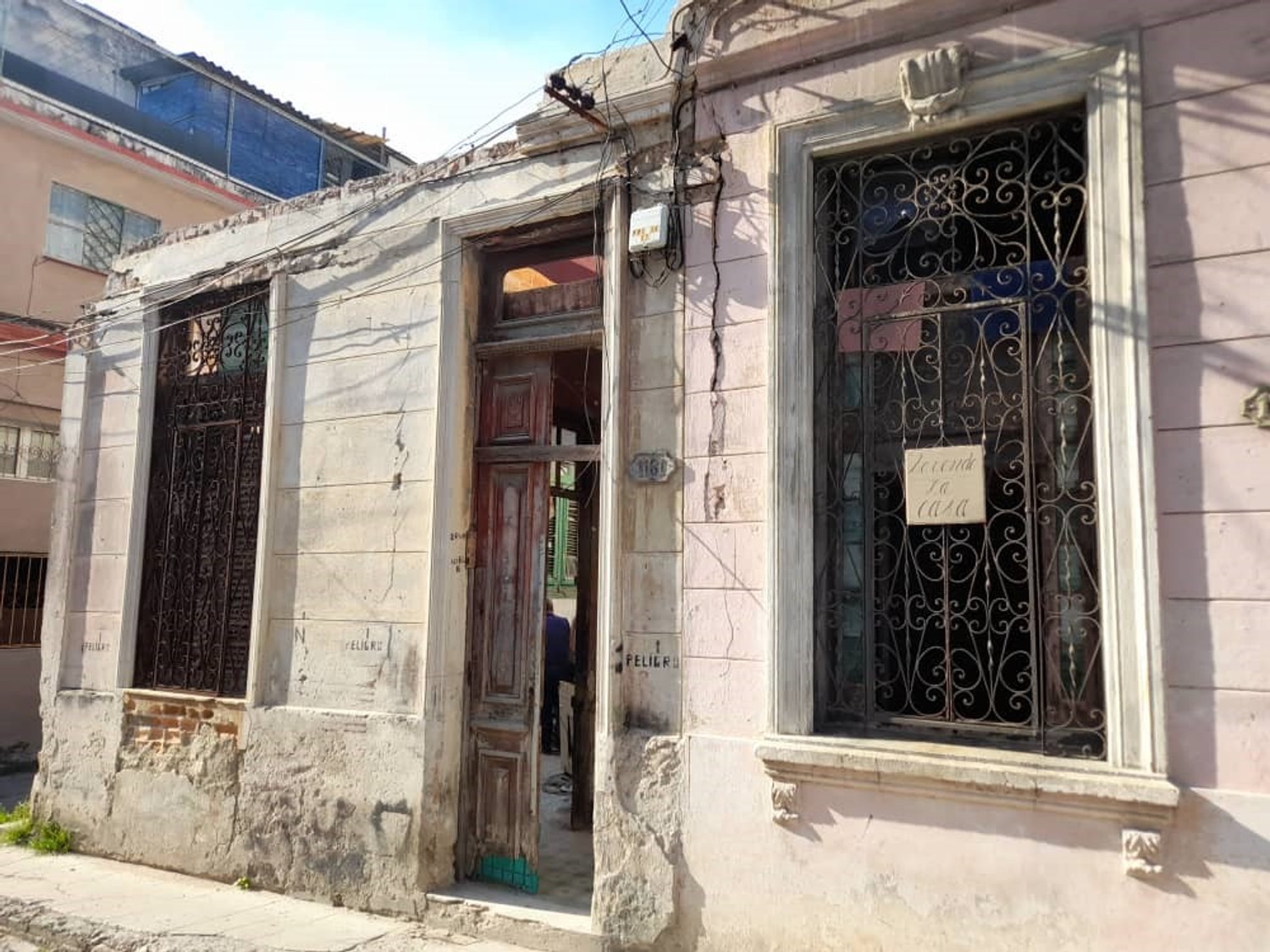 foto de una casa en Cuba con el cartel "se vende" pegado a la ventana 