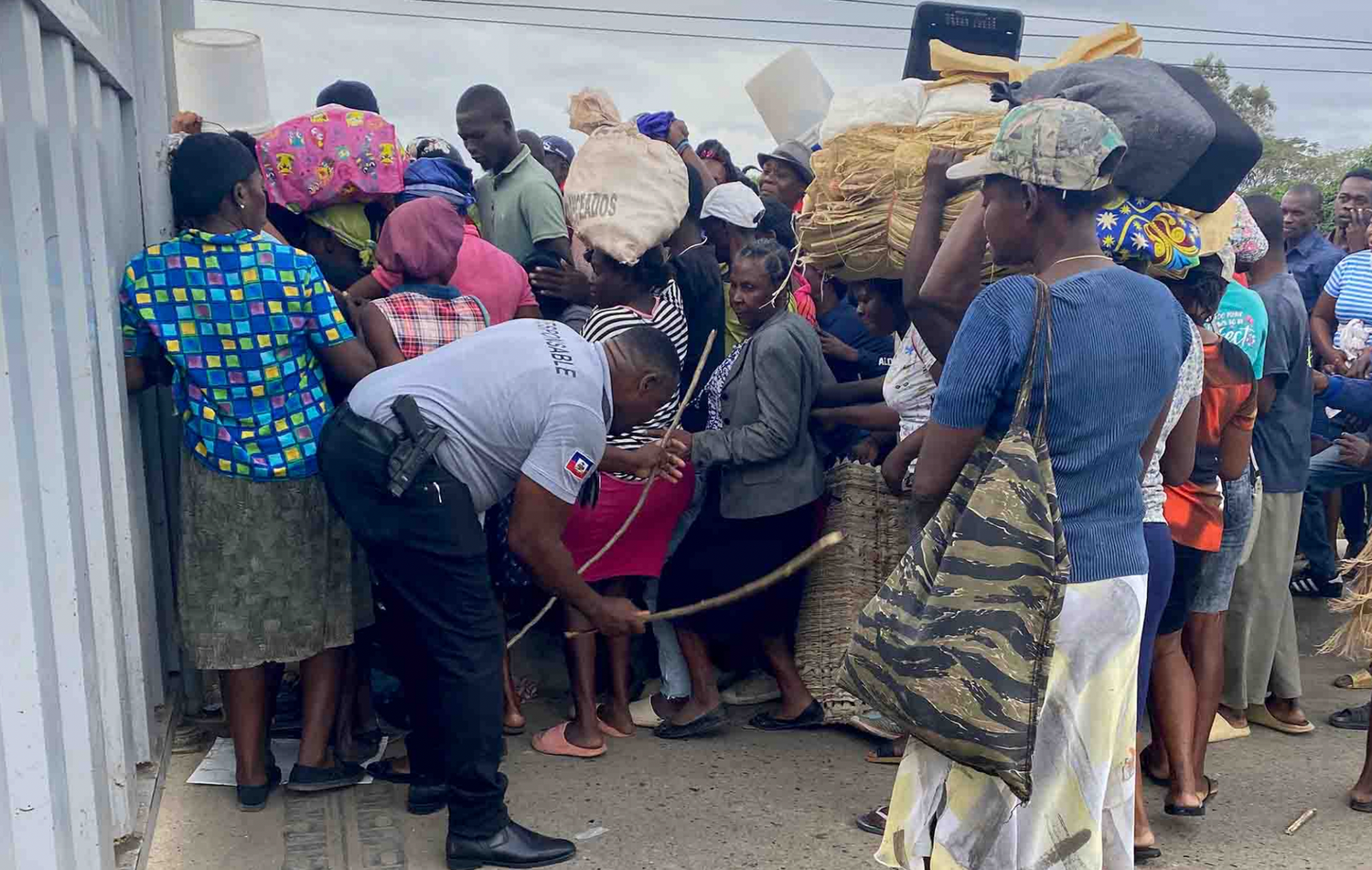 Un traficante de haitianos muestra un fajo de dólares frente al portón fronterizo de Dajabón. 