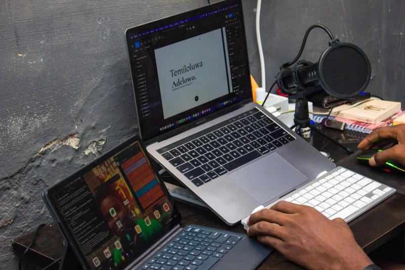 Lucid's workspace as at April 2023, featuring a MacBook Pro 13 inch, 2017, with the text: 'Temiloluwa Adelowo' being shown on the laptop. In the picture are other gadgets, like a Lenovo tablet, a mini USB microphone, and a white keyboard