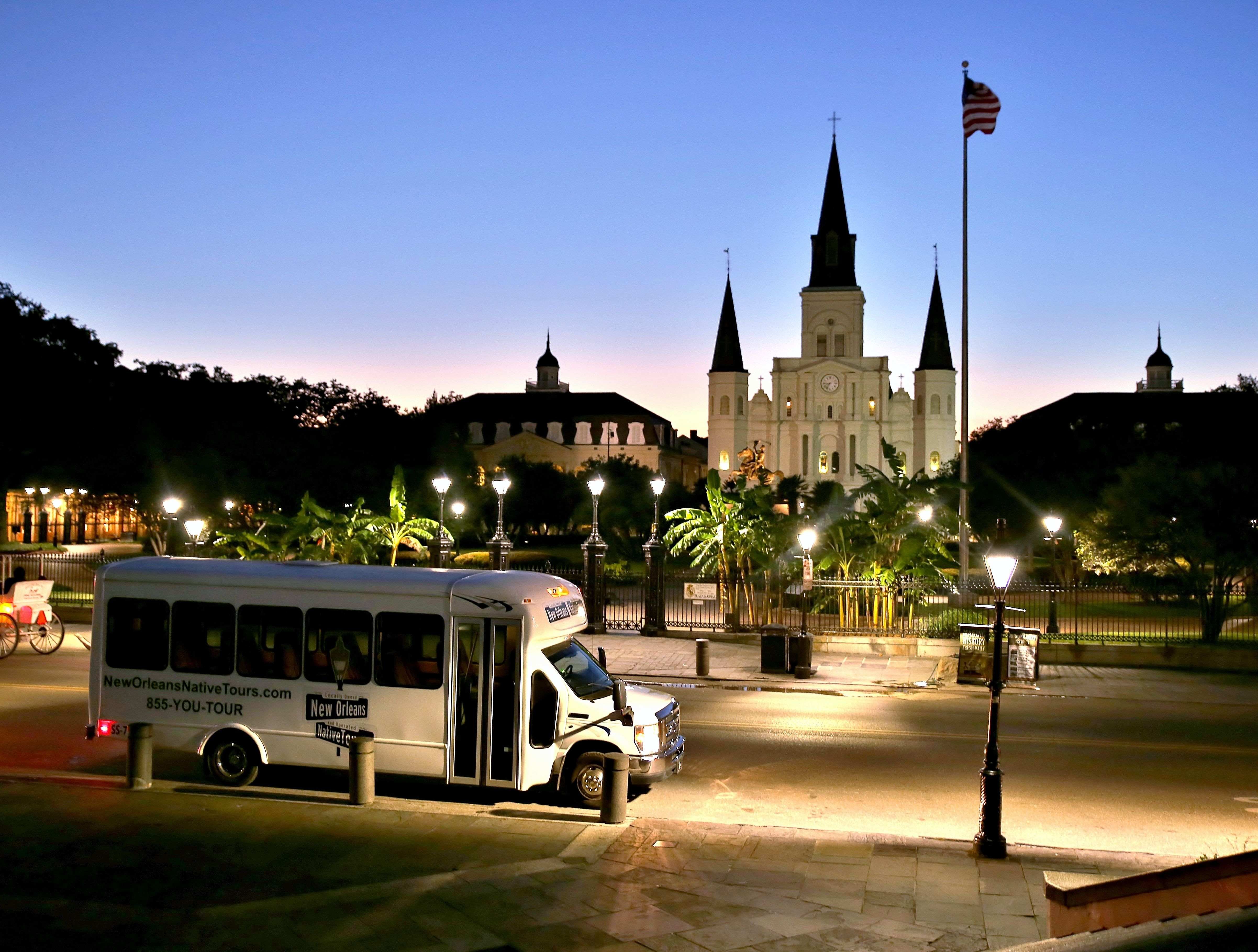 Tour bus parked at Jackson Square with St. Louis Cathedral at golden hour