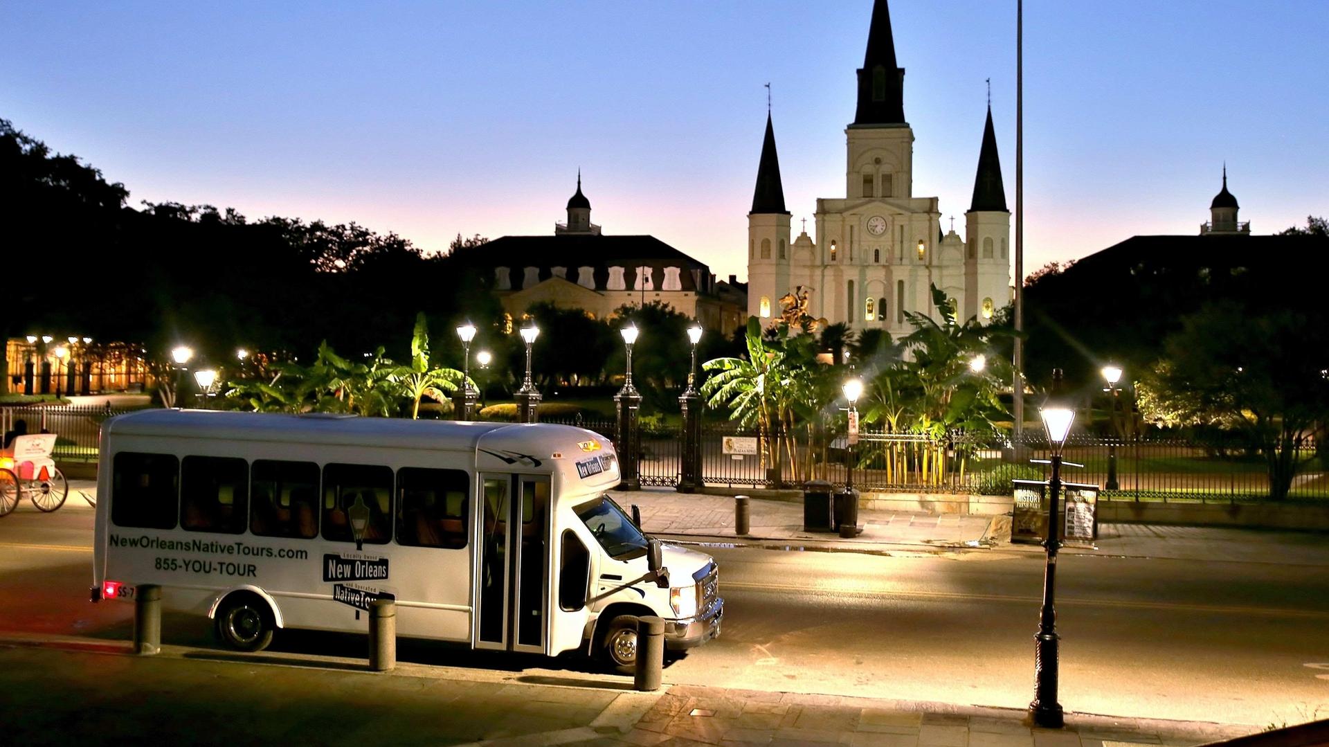 Tour bus parked at Jackson Square with St. Louis Cathedral at golden hour