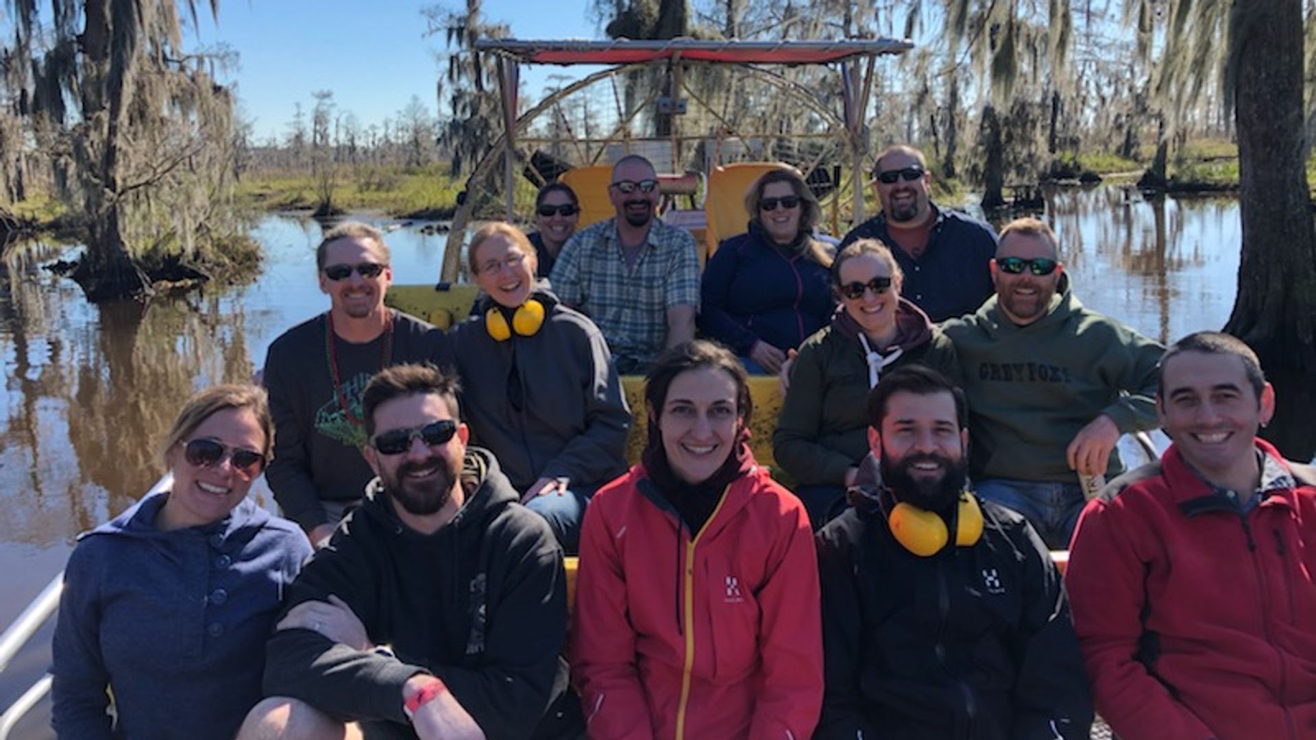 Private group smiling with Cajun captain on exclusive airboat charter in Louisiana swamp