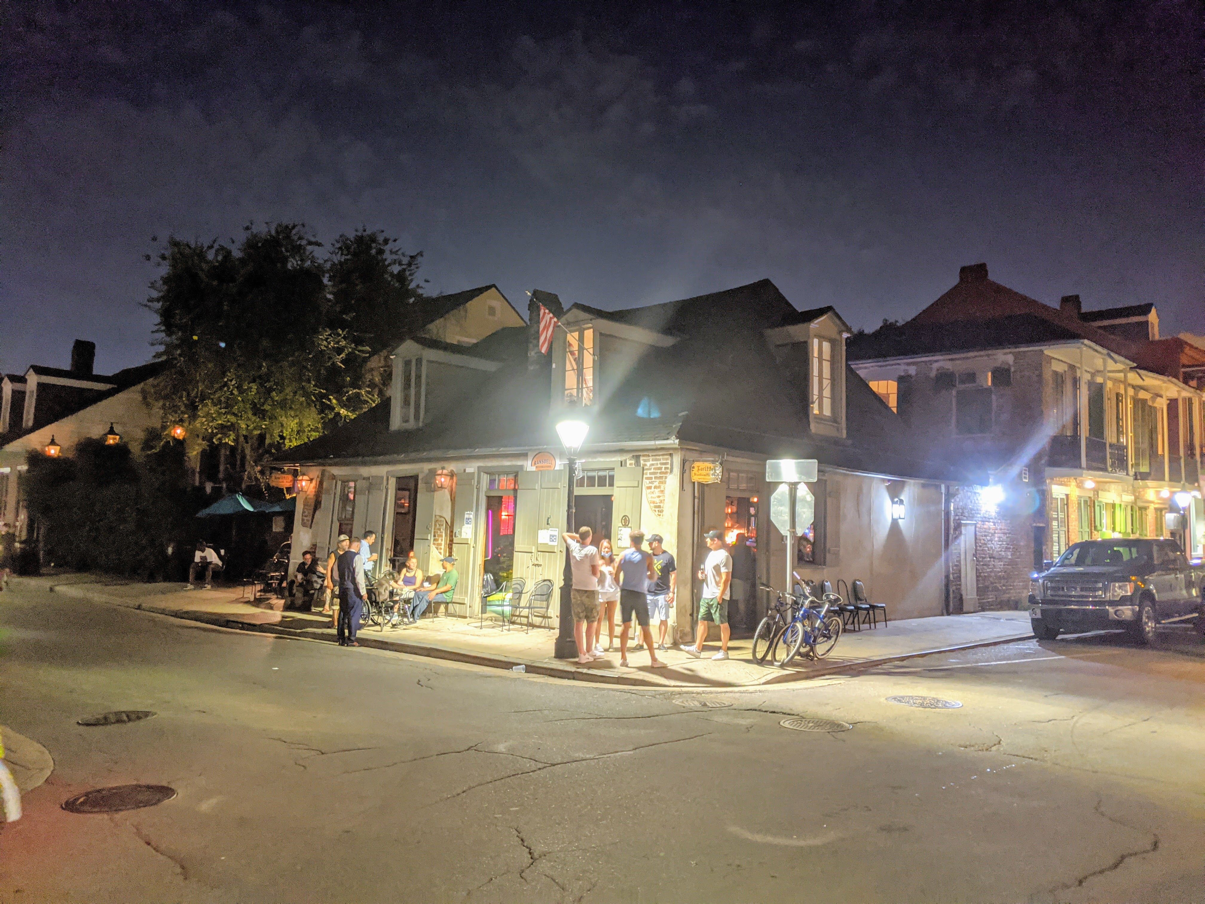 Lafitte's Blacksmith Shop Bar illuminated at night with guests gathered outside