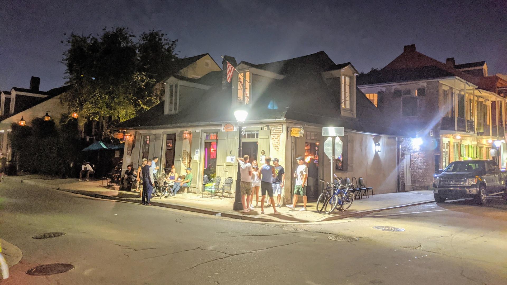 Lafitte's Blacksmith Shop Bar illuminated at night with guests gathered outside