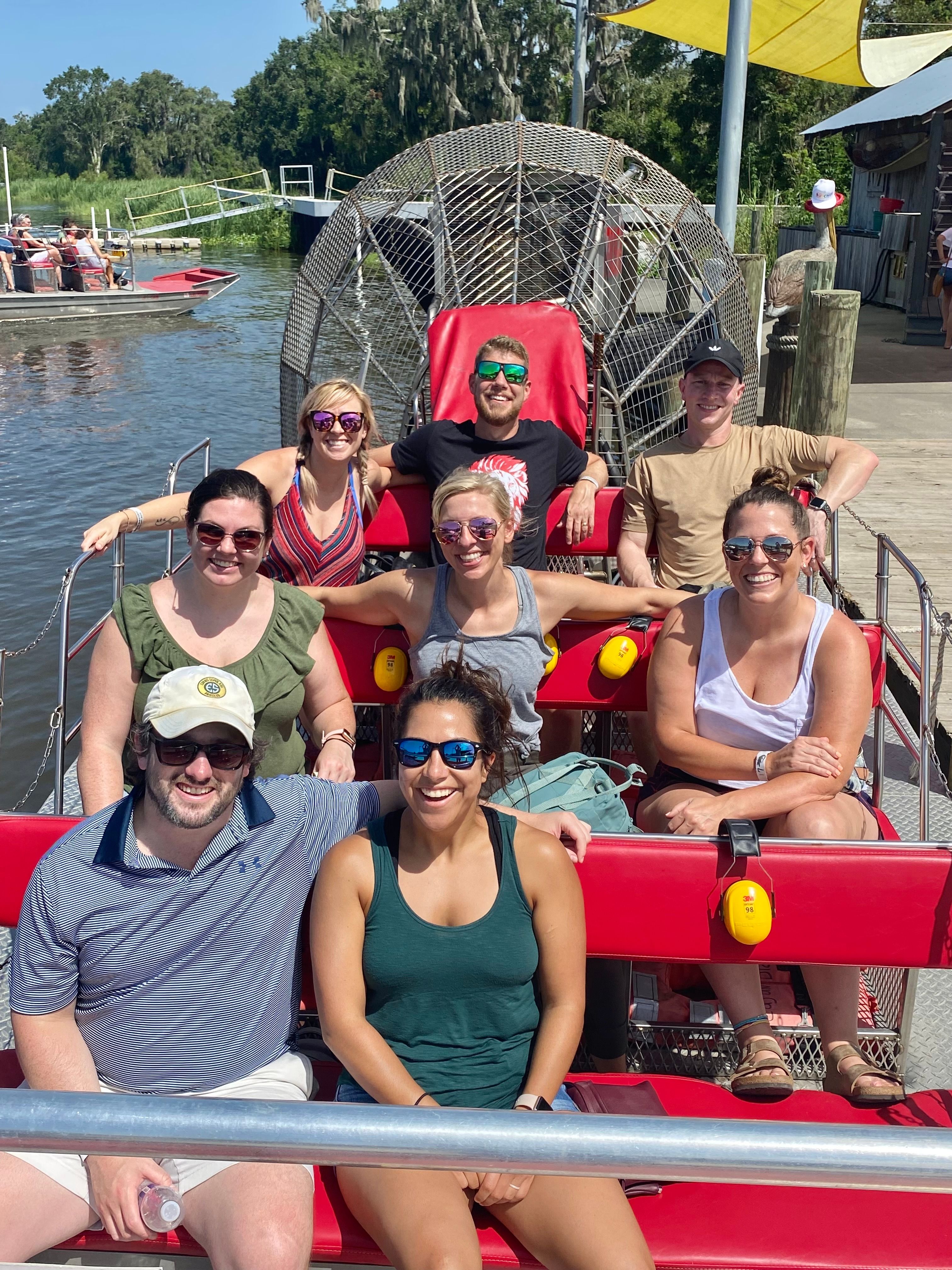 Friends enjoying private airboat tour on red boat in New Orleans bayou