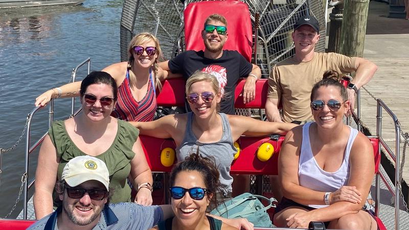 Friends enjoying private airboat tour on red boat in New Orleans bayou