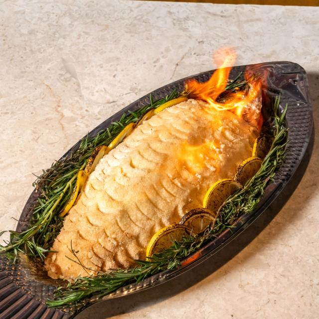 Loup de mer entier en croûte de sel, flambé en salle chez Bisou Phuket
