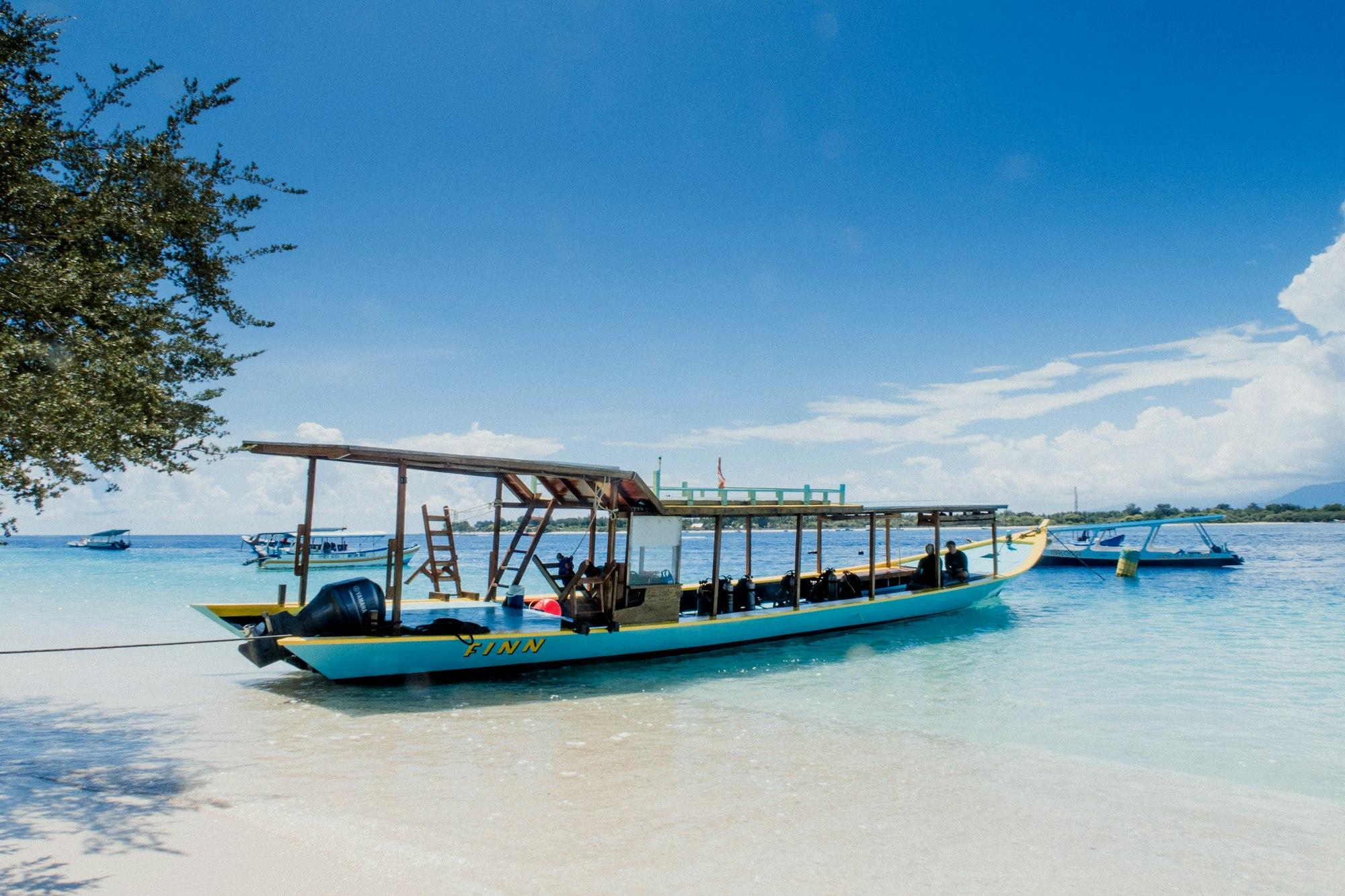 Perahu wisata bersandar di pantai pasir putih Gili