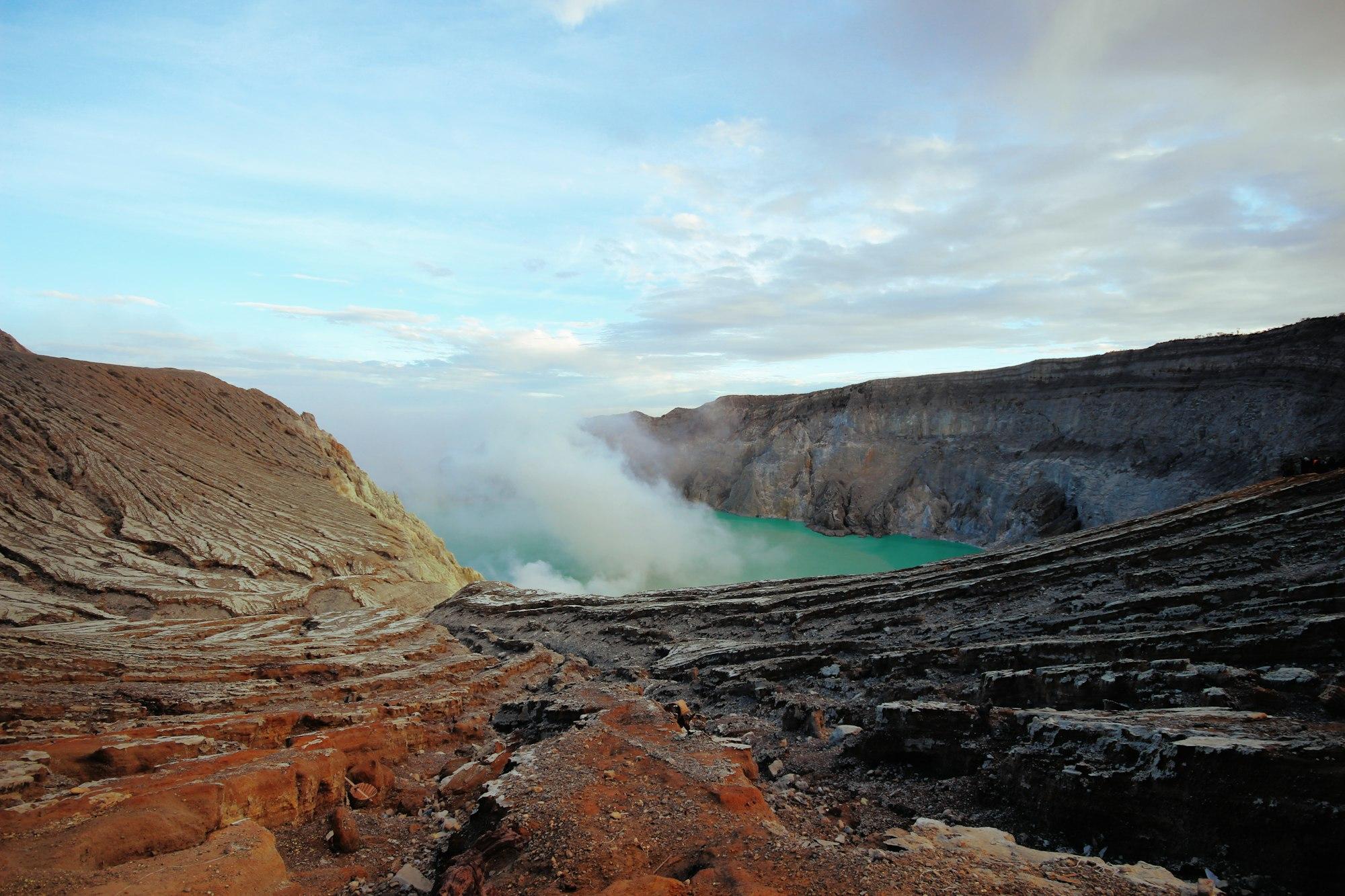Lereng berbatu kawah Ijen dengan asap belerang