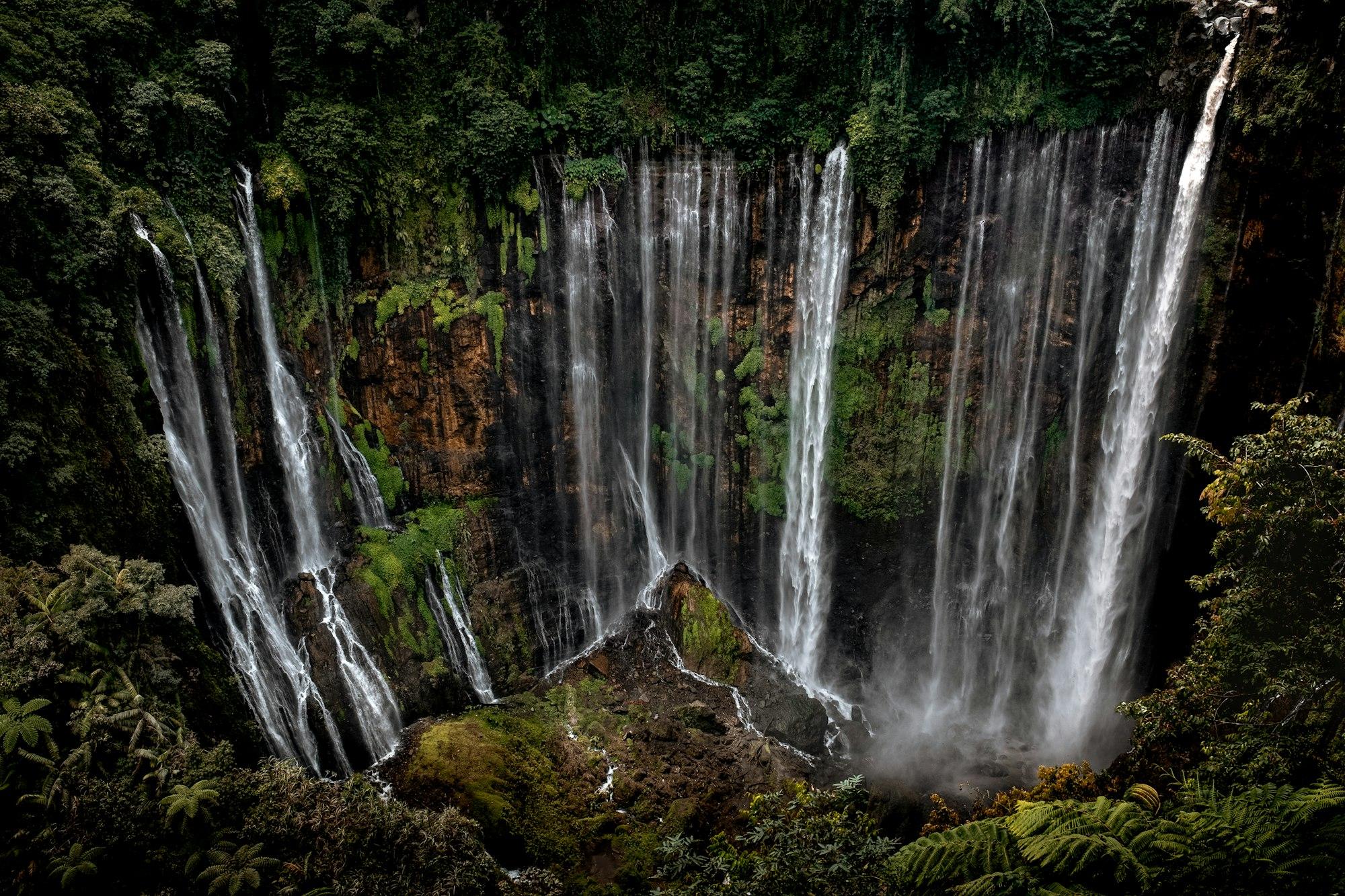 Tirai air terjun Tumpak Sewu di dinding tebing hijau