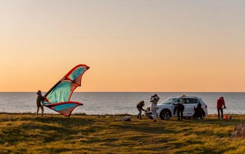 Volkswagen VW Tiguan in Latvian landscape in front of people kiting. Car subscription