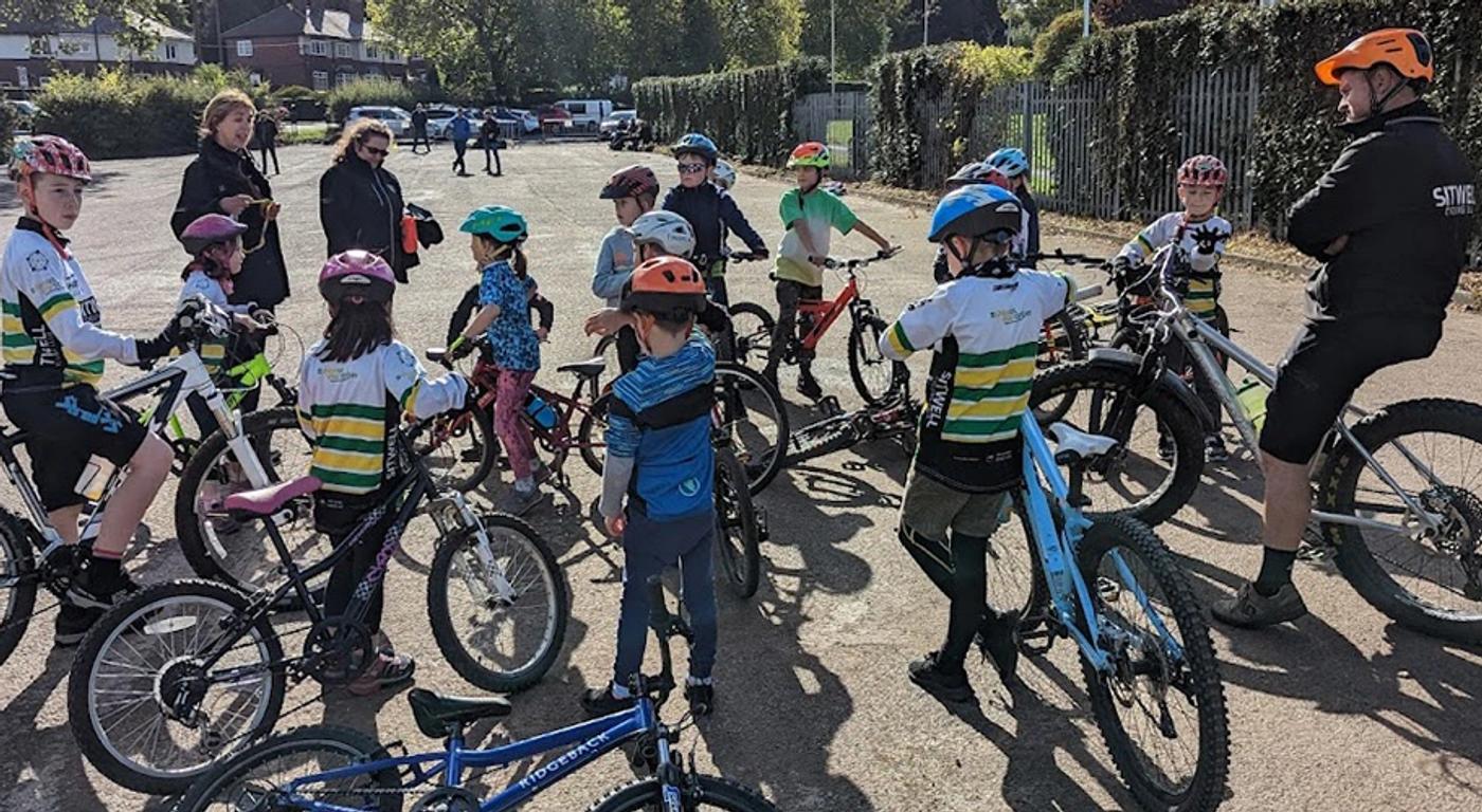 A photograph of our Go-Ride coaching group listneing to intructions from a mix of club coaches