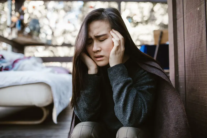 Person resting with a headache and discomfort around the eyes