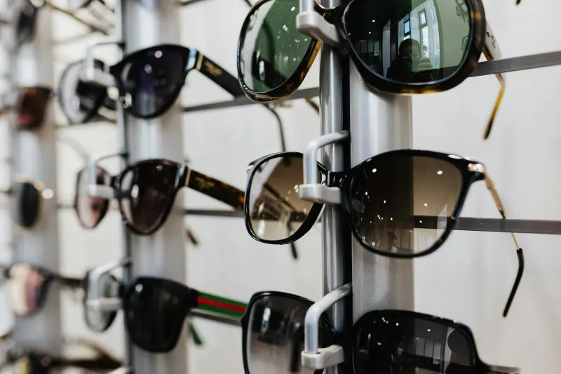 Close-up view of stylish sunglasses displayed on a rack in a retail store.